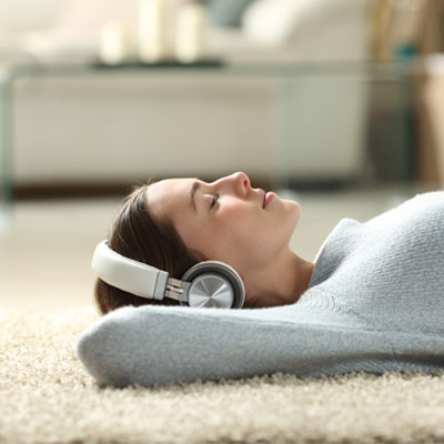 woman enjoying floor time on carpet with headphones